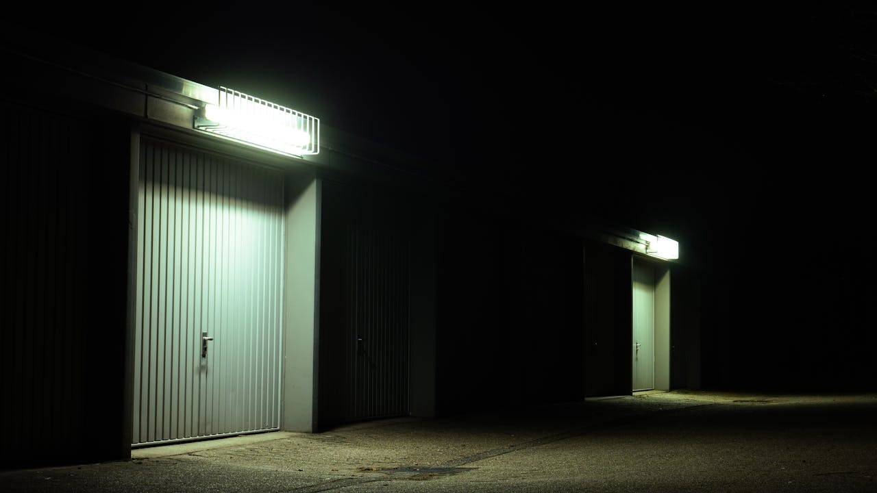 Dimly lit garage doors illuminated by overhead lights in a serene night setting in Germany.