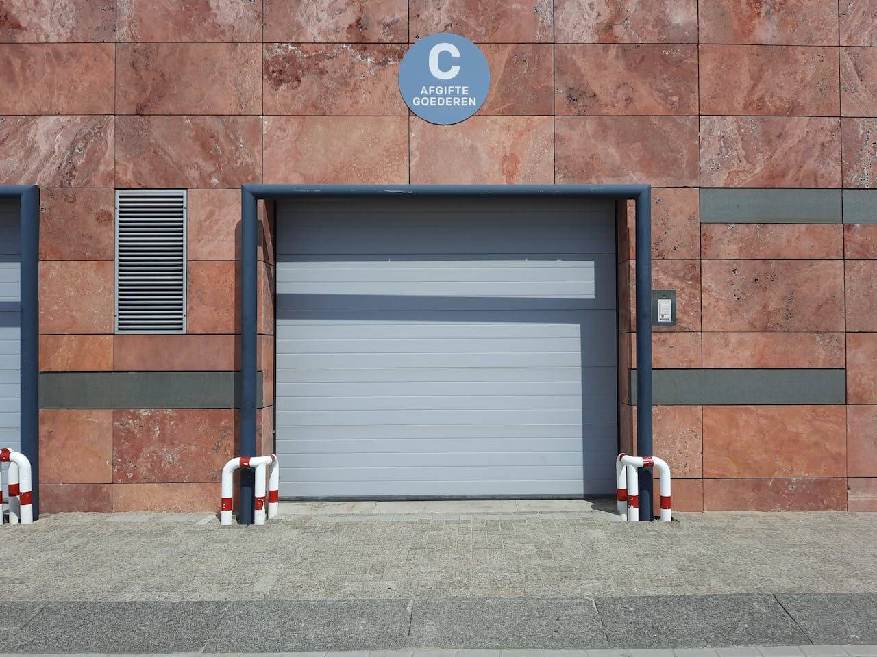 Front view of a modern urban garage entrance with clear signage in natural light.