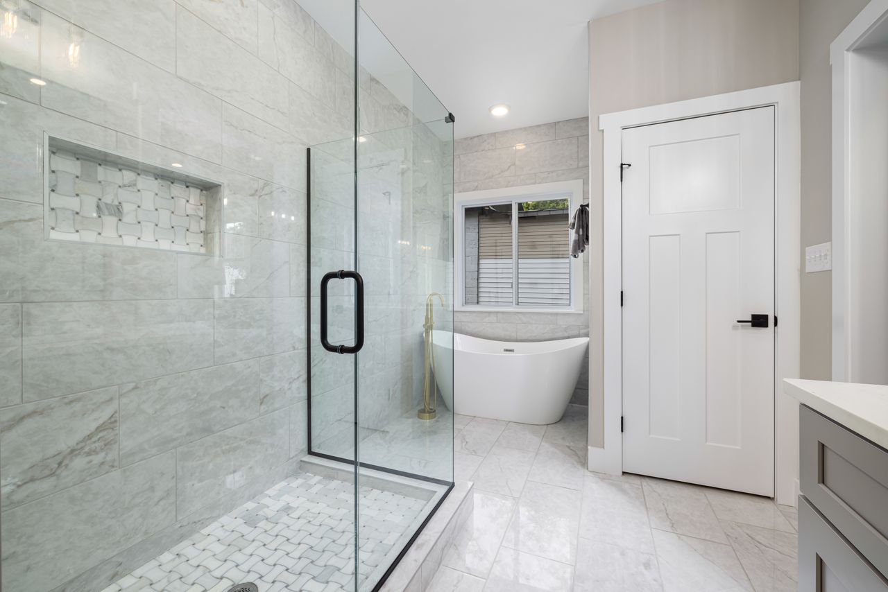 Bright modern bathroom featuring a glass shower and freestanding bathtub. Perfect for design inspiration.