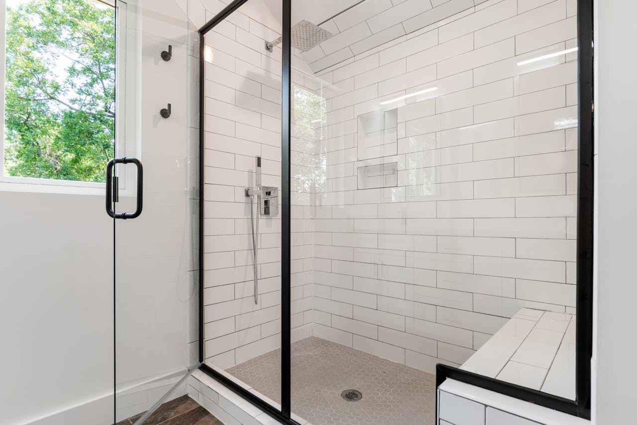 Sleek and modern shower with glass panels and tiled walls in a bright bathroom.