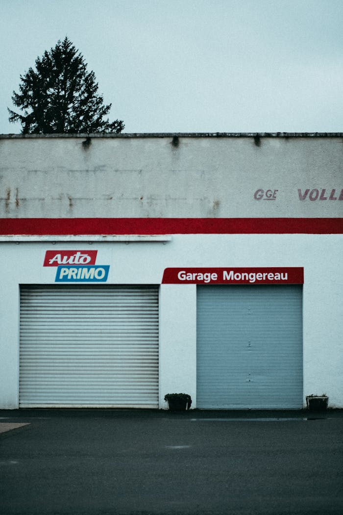 Front view of an auto garage with roll-up doors and signage, suitable for automotive business themes.