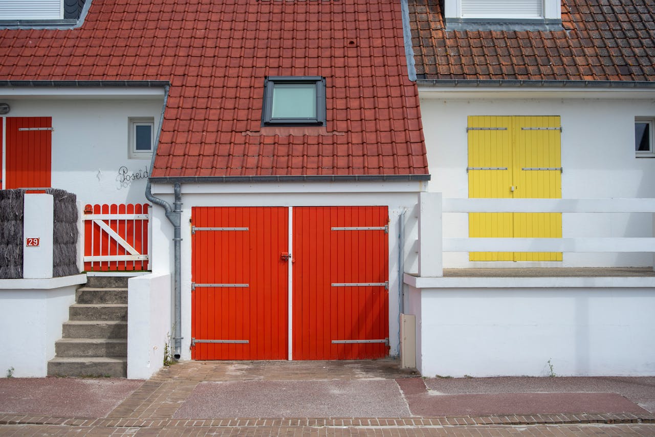 Brightly colored house facade featuring red and yellow doors and a red tiled roof.