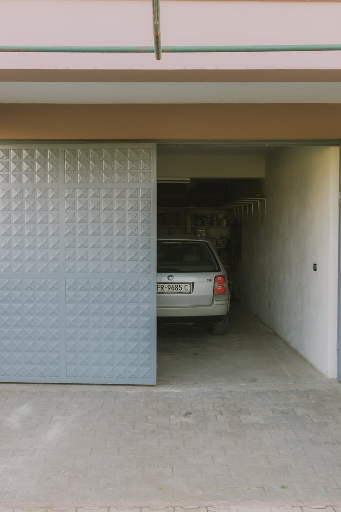 Partially open garage with parked car visible inside, featuring a modern sliding door design.